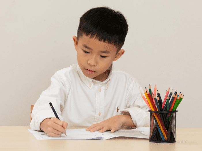 Boy writing on worksheet