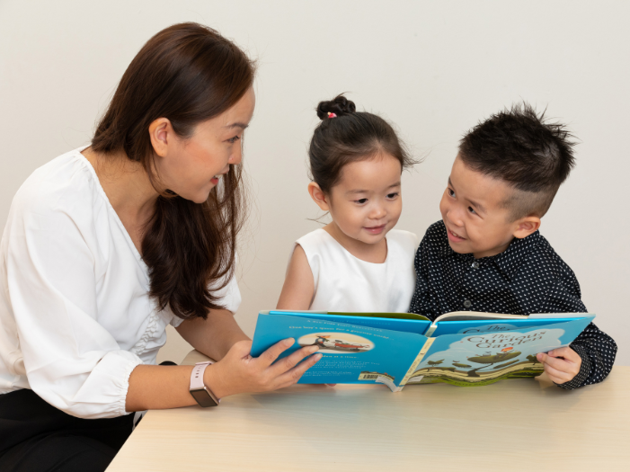 Teacher guiding the children to read a book